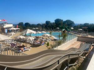 un resort con piscina con persone sdraiate sulle sedie di Mobilhome 6 places vue mer a Drammont