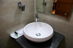 a white sink in a bathroom with a mirror at Hotel U.T.Elegance in Bangalore +25 photos