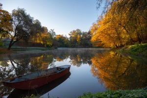 un barco sentado en el agua en un lago en Szobi Malomkert Bagolyvár en Szob