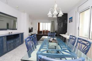 a dining room with blue chairs and a table at COSTA DAURADA APARTAMENTS - Residencial Rits in Salou