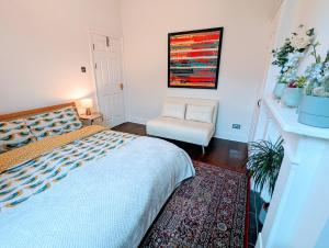 ein Schlafzimmer mit einem Bett und einem Stuhl in der Unterkunft TopHome Arsenal in London