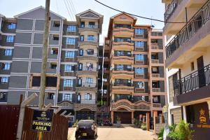 un grand bâtiment avec une voiture garée devant lui dans l'établissement Lux Suites Imperial Heights Ruiru, à Ruiru