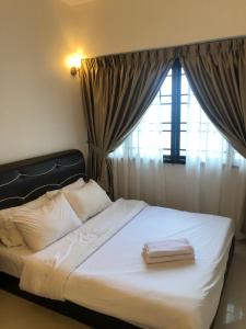 a bed with two books on it in front of a window at Beach Resort Home Stay Batu Ferringhi 02 in Batu Ferringhi +14 photos