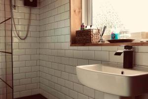 a white tiled bathroom with a sink and a window at Jackson place in Newton Aycliffe