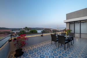a balcony with a table and chairs on a building at O Pierre in Panaji