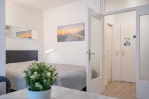 una camera con un letto e un tavolo con un vaso di fiori di Apartmentanlage Wennseestraße Lüttje Doens a Scharbeutz