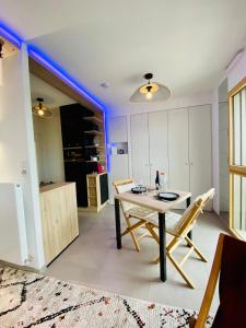 une salle à manger avec une table et des chaises ainsi qu'une cuisine dans l'établissement Studio BEL MOD Mont d'Or - Belvédère Moderne, à Lyon