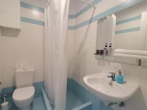 a bathroom with a white toilet and a sink at Ithaca in Perdika