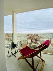 a chair on a balcony with a view of a city at Studio BEL-MOD BUGEY - Belvédère Moderne in Lyon