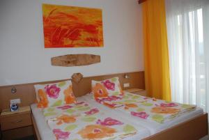 1 cama con 2 almohadas y una pintura en la pared en Pension Agnes, en Sankt Kanzian