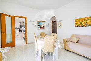 comedor y sala de estar con mesa y sofá en Casa Namaka - Piano Primo Fronte mare, en Porto Cesareo