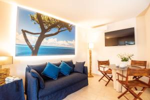 - un salon avec un canapé bleu et une table dans l'établissement Mariva Dune Suites, à San Vincenzo