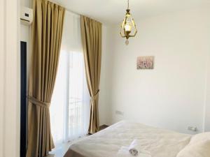 1 dormitorio con cama y ventana grande en Luxury Two-Bedroom Apartment in amazing place Lukomorye E5, en Karavas