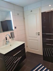 a bathroom with a sink and a mirror and a door at Exklusive Ferienwohnung nahe der Nordsee in Wesselburen