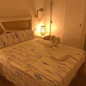 a bedroom with a large white bed with a lamp at Apartamento Adrover - J in Sant Llorenç des Cardassar