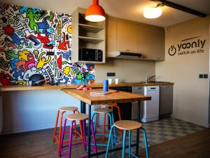uma cozinha com uma mesa e bancos numa cozinha em travelski home select - Résidence & Hostel Yoonly & Friends em Risoul