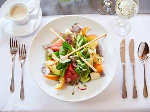 ein weißer Teller mit Salat auf dem Tisch in der Unterkunft Hotel "Krone" - Immenstadt-Stein in Immenstadt im Allgäu