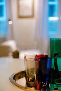 - un plateau avec des verres colorés différents sur une table dans l'établissement GITADIN - Deluxe Suite Valens - Historical Center, à Liège