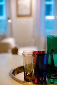 ein Tablett mit verschiedenen farbigen Gläsern auf einem Tisch in der Unterkunft GITADIN - Deluxe Suite Valens - Historical Center in Lüttich
