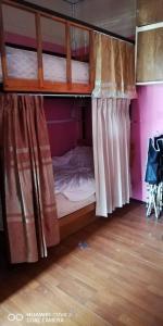 a bedroom with a bunk bed with curtains at บ้านโอเค โฮสเทล OK HOME hostel in Ban Khlong Thewa