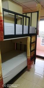 a bunk bed in a room with white sheets at บ้านโอเค โฮสเทล OK HOME hostel in Ban Khlong Thewa