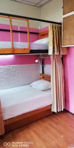 two bunk beds in a room with pink walls at บ้านโอเค โฮสเทล OK HOME hostel in Ban Khlong Thewa