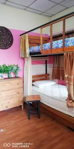 Ban Khlong Thewaにあるบ้านโอเค โฮสเทล OK HOME hostelのウッドフロアのドミトリールームの二段ベッド2台分です。