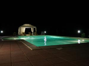 a swimming pool with a gazebo at night at Agriturismo La Prosciutta in Faenza