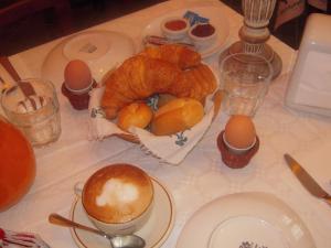 una mesa con huevos y una cesta de cruasanes en Agriturismo La Prosciutta, en Faenza