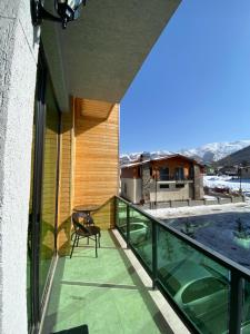 a balcony of a house with a chair on it at Snow Forest Bakuriani Apartment 10 in Bakuriani