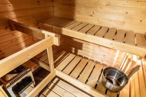 an inside view of a wooden sauna with a bucket at Apartment, SleepWell, Tyynimeri with private parking and optional private sauna in Helsinki