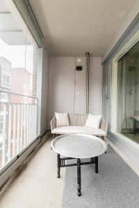 a balcony with a couch and a coffee table at Apartment, SleepWell, Tyynimeri with private parking and optional private sauna in Helsinki