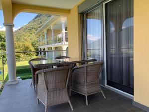 a patio with a table and chairs on a balcony at Apartment Casa Wiro in Magadino