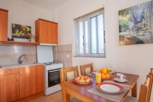 een keuken met een houten tafel en een eetkamer bij Agios Sostis Village Apartments in Laganas