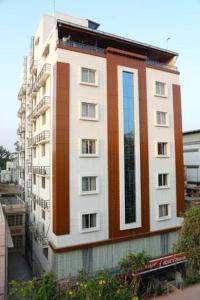 a tall white and orange building on a city street at Hotel U.T.Elegance in Bangalore