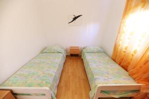 Pokój z 2 łóżkami i oknem w obiekcie Apartments Melita w mieście Zadar