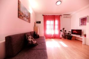 salon z kanapą i oknem w obiekcie Apartments Melita w mieście Zadar