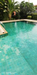 una gran piscina de agua azul en บ้านโอเค โฮสเทล OK HOME hostel, en Ban Khlong Thewa