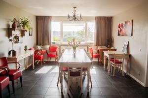 a dining room with a table and red chairs at LOGIES Tuin der Zinnen in Rijkevorsel
