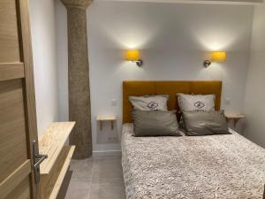 a bedroom with a bed with two pillows on it at Appart' Au Coeur de Nuits in Nuits-Saint-Georges