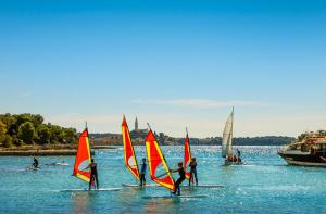a group of people on sailboats in the water at Maistra Camping Amarin Glamping in Rovinj