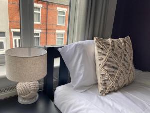 a bed with a table and a pillow and a window at The Dockyard in Goole