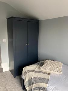 a bedroom with a black cabinet next to a bed at The Dockyard in Goole