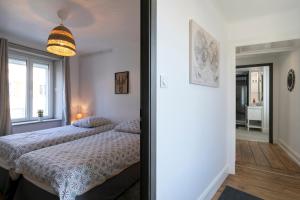 a bedroom with a bed and a large window at Appart-Hôtel-Darney in Darney