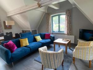 un salon avec un canapé bleu et une télévision dans l'établissement Cottage, Plau am See, à Plau am See
