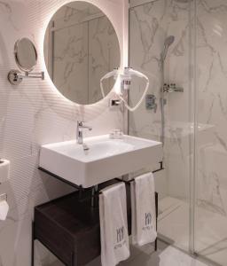 a bathroom with a sink and a mirror and a shower at Hotel Nena in Istanbul