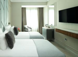 a hotel room with two beds and a flat screen tv at Hotel Nena in Istanbul