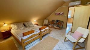 a small room with two beds and a chair at Napospatak Apartmanház in Orfű