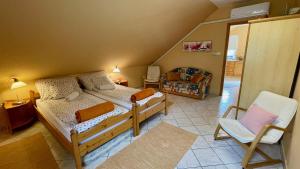 オルフェにあるNapospatak Apartmanházのベッド2台と椅子が備わる小さな客室です。