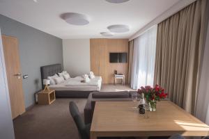 salon ze stołem i łóżkiem w obiekcie Czarny Kamień Resort & SPA w Szklarskiej Porębie